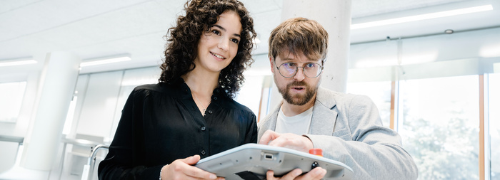 Tandem_Studium_WING | © FH Kufstein Tirol Eine Frau hält ein Steuerungsgerät für eine Maschine. Ein Mann neben ihr bedient das Steuerungsgerät. | © FH Kufstein Tirol